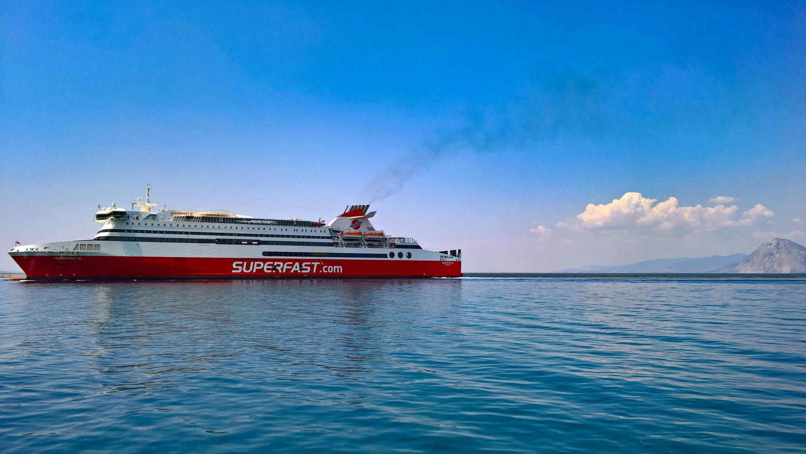 Red and white cruise ship on a sunny day in the Ionian Sea near Patras, Greece.